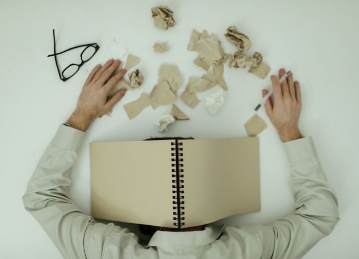 Person at a desk with crumpled paper